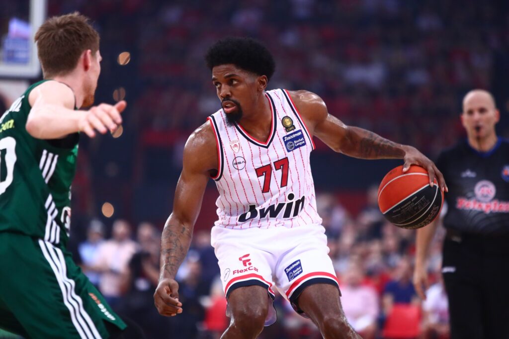 Photo by Olympiacos B.C. on June 12 2024. May be an image of 3 people people playing basketball ball backboard stadium basketball court and text